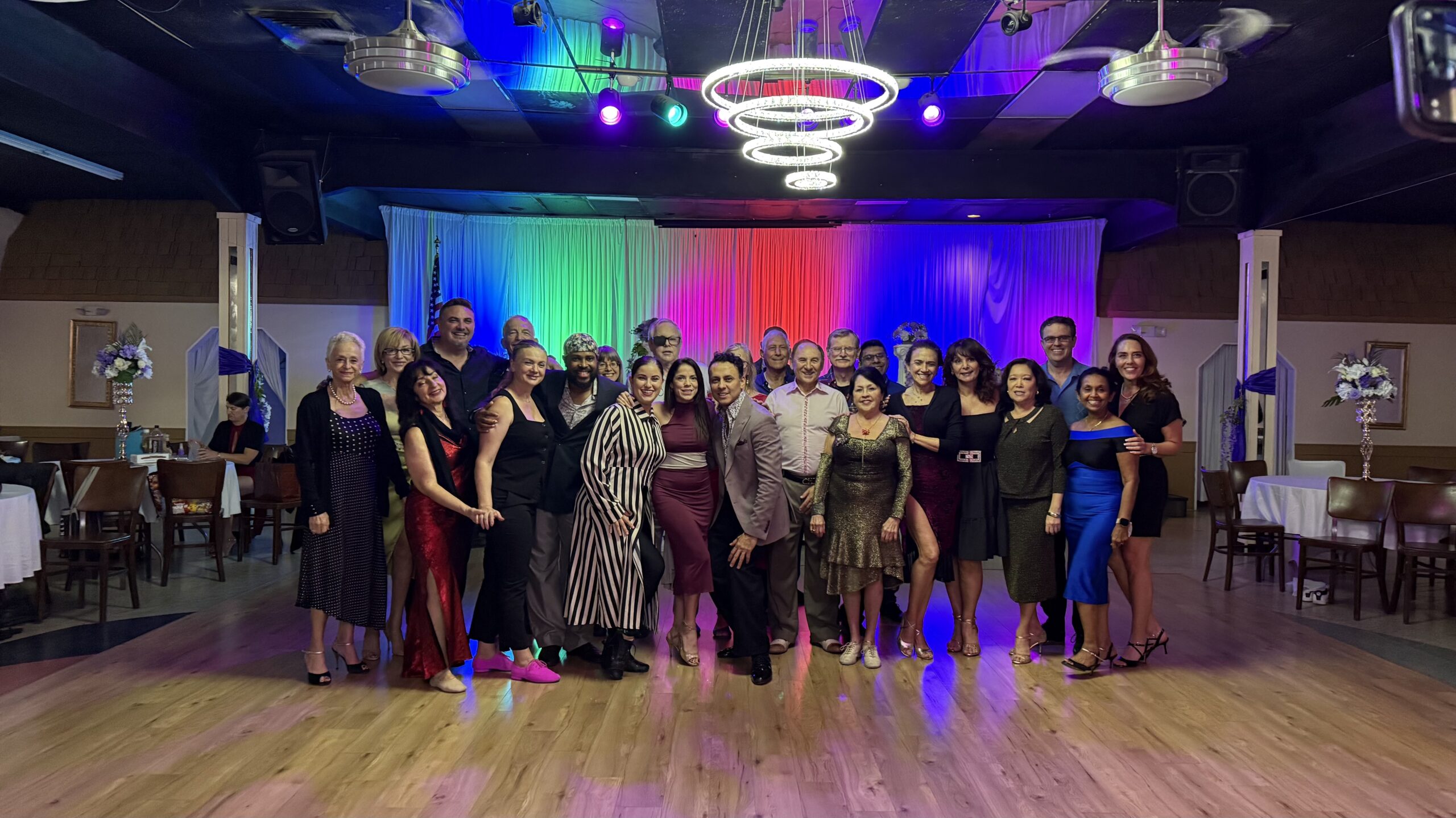Large group photo with colorful stage lighting